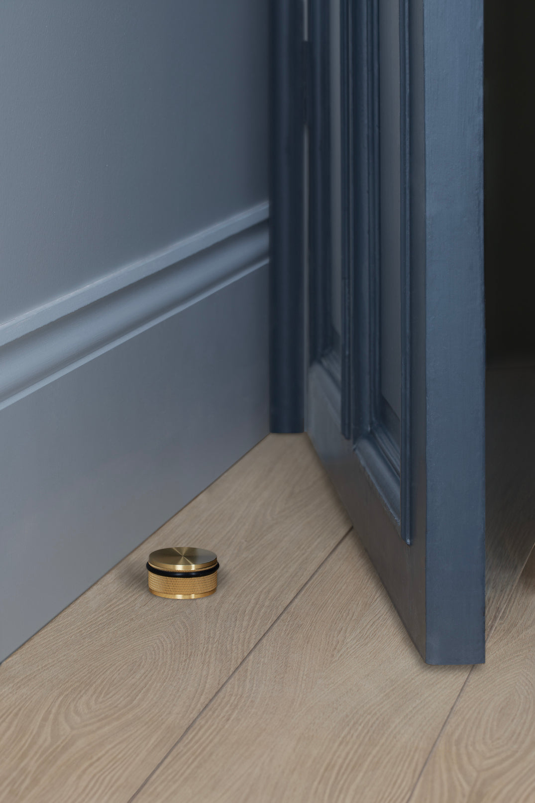 A Buster & Punch door stop in brass