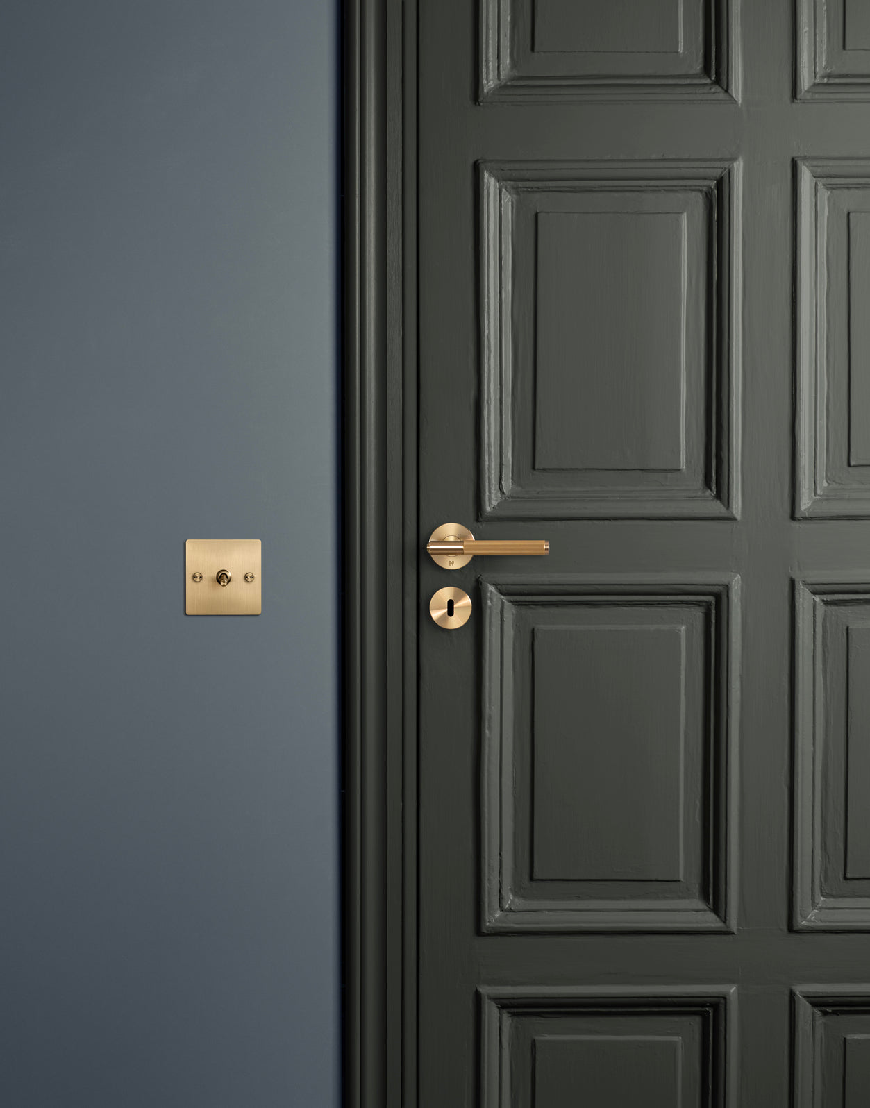 Picture of a green door with a Buster & Punch door handle and a wall with a Buster & Punch light switch