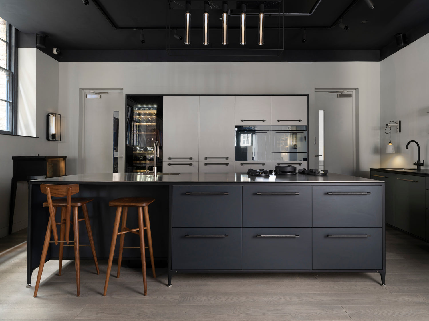 Modern Buster & Punch kitchen with off black island and stone grey tall unit walls