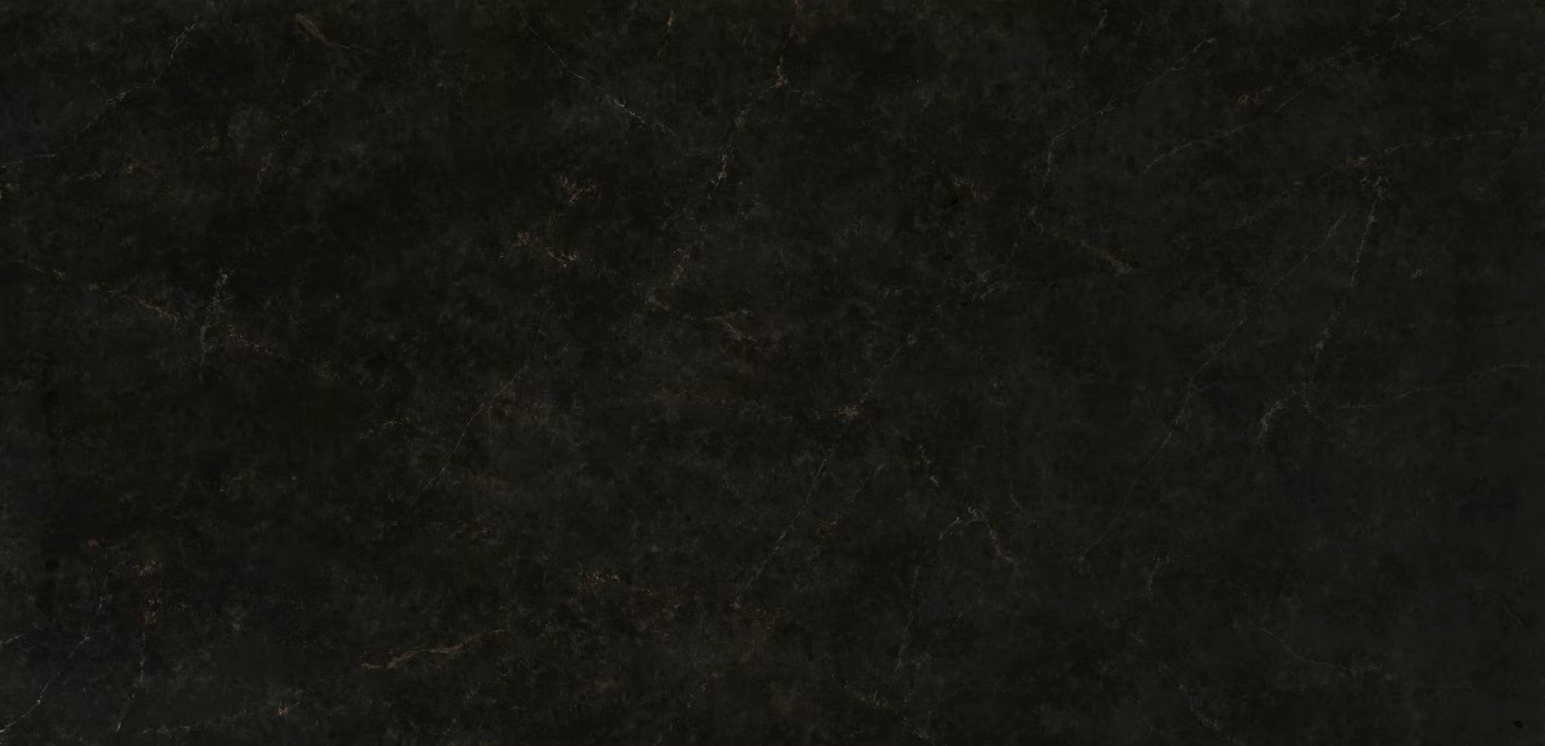 A close-up of a dark textured surface, likely a black stone, tile, or leather material with subtle warm brown veining.