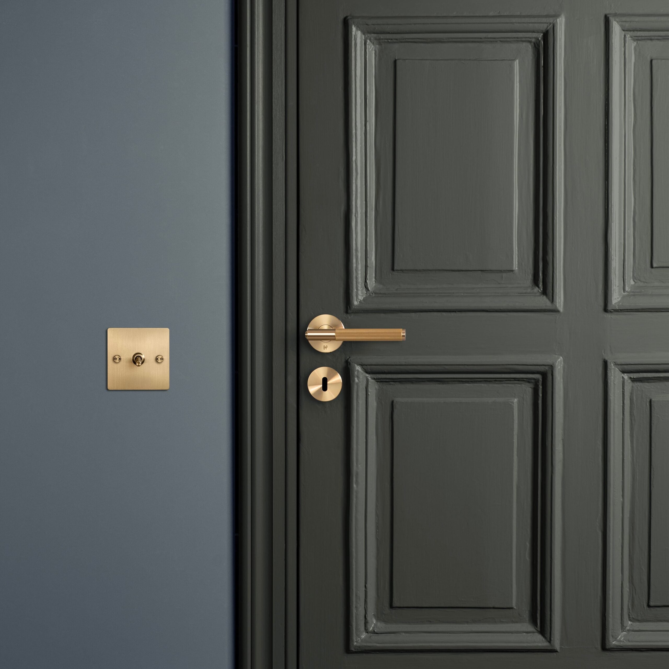 Green door with brass Buster & Punch door handle and key escutcheon