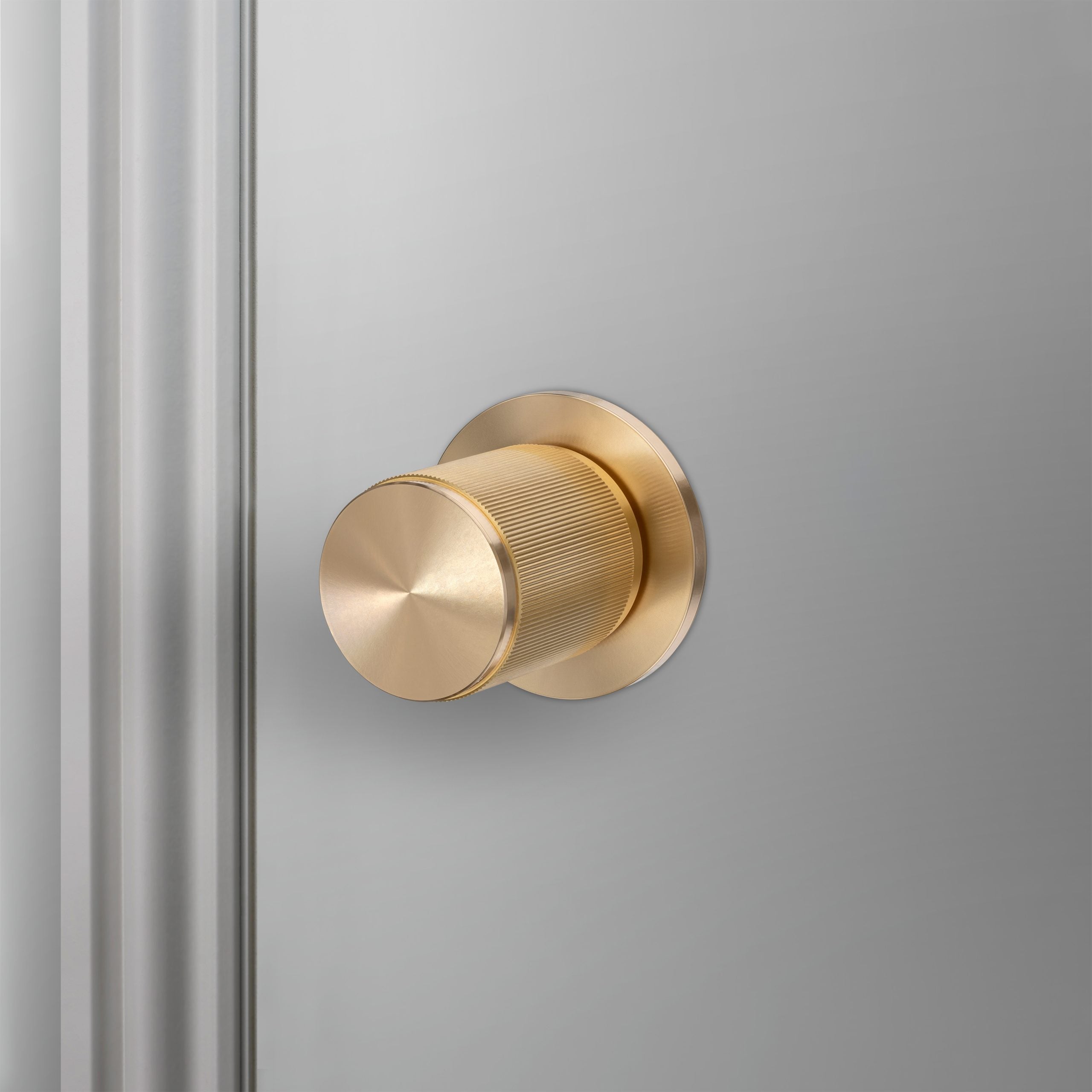 A Buster & Punch door know in cross-pattern brass