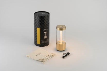 Buster &amp; Punch Takeout lamp in Brass with packaging, drawstring bag, and USB cable on a light gray background