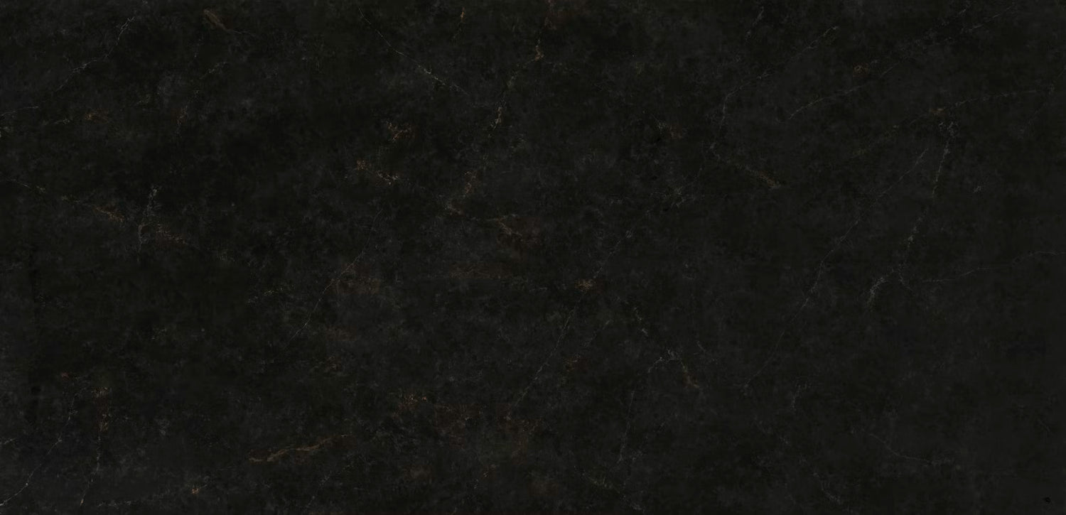 A close-up of a dark textured surface, likely a black stone, tile, or leather material with subtle warm brown veining.