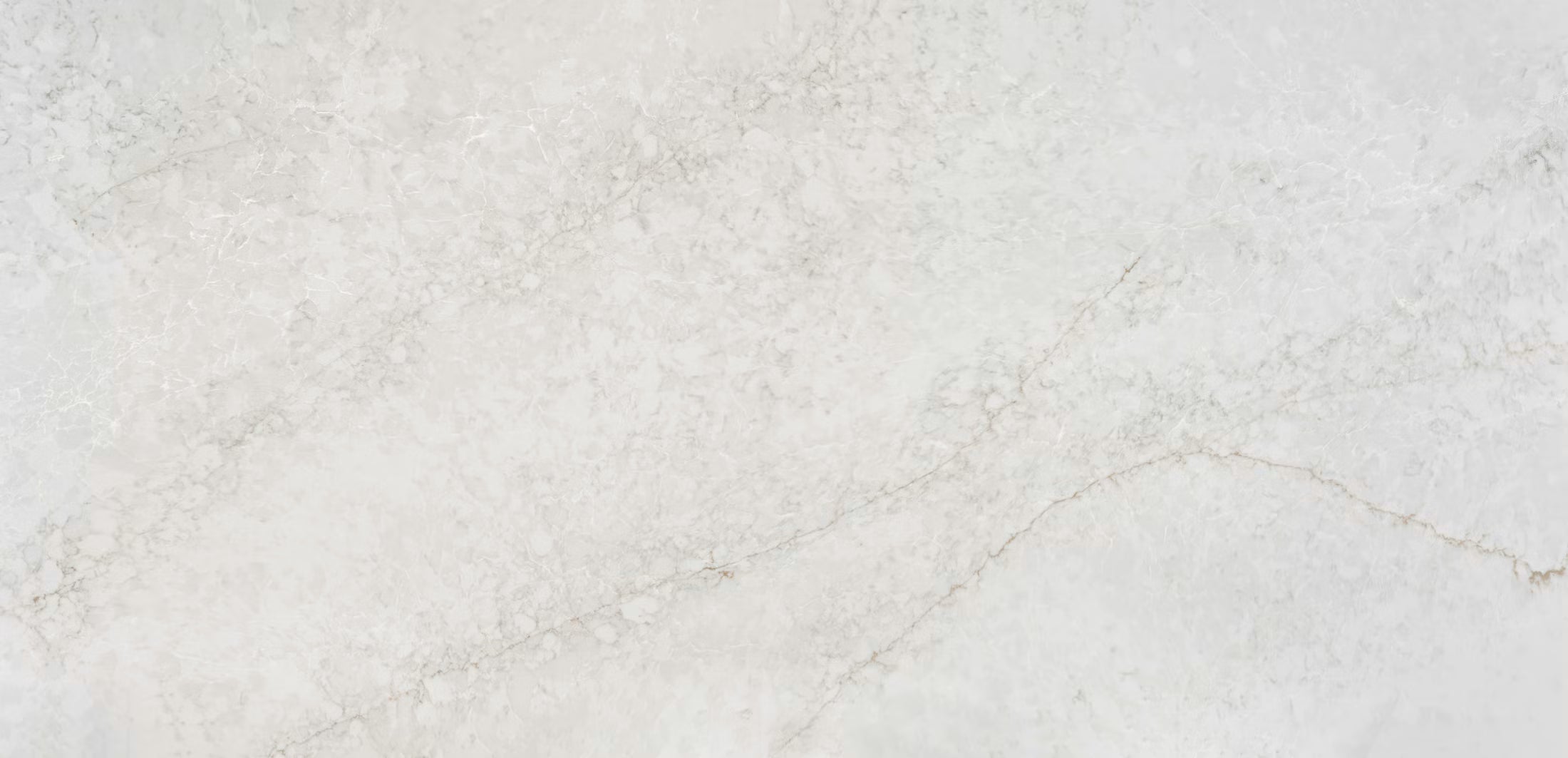 A close-up of a light beige stone or marble surface with subtle natural veining and a slightly textured finish.